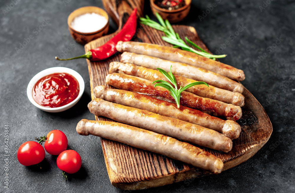 
Thin grilled meat sausages on a stone background