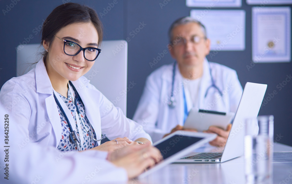 Serious medical team using a laptop in a bright office Serious medical team using a laptop in a bright office
