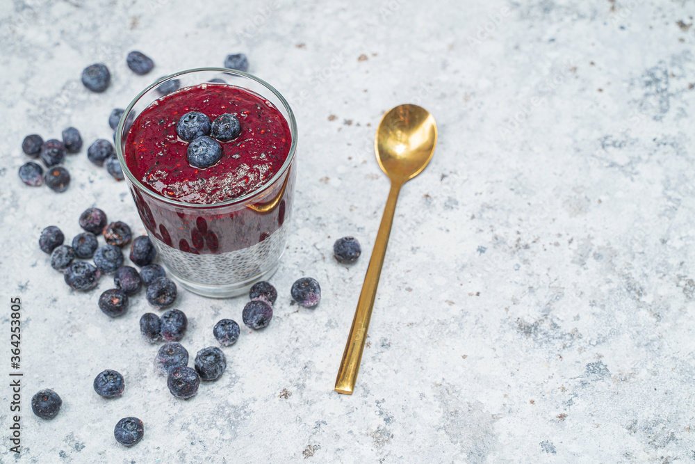 Healthy breakfast or morning snack with chia seeds and blueberries on white stone background, vegetarian food, diet and health concept. Healthy breakfast or morning snack with chia seeds and blueberries on white stone background, vegetarian food, diet and health concept.
