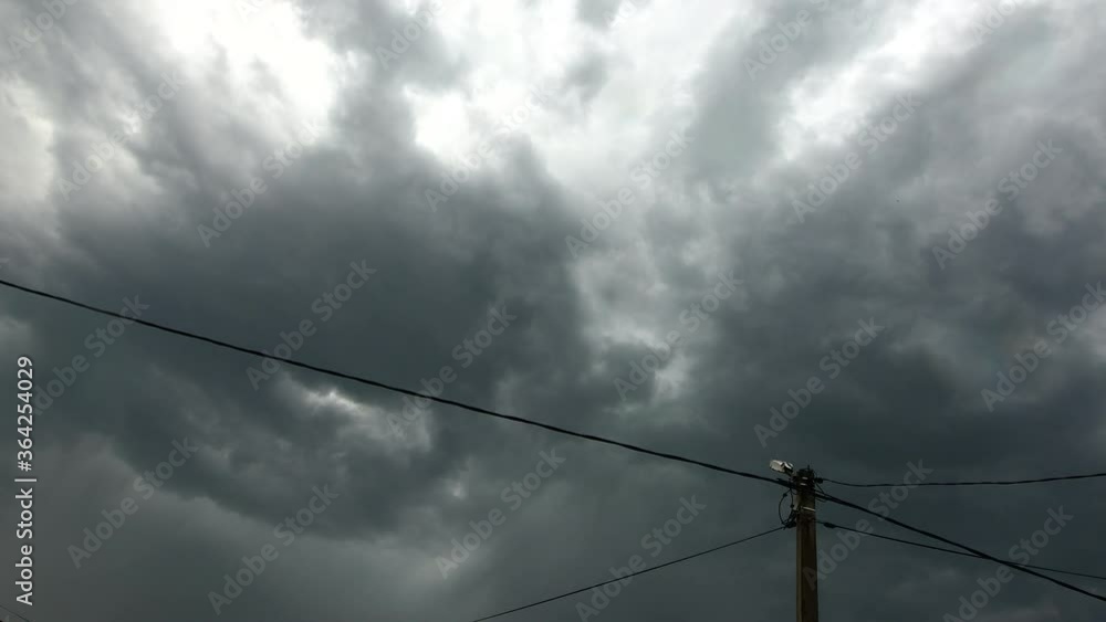 Stormy cyclone and rain clouds sweep over the electrical support and wires Stormy cyclone and rain clouds sweep over the electrical support and wires