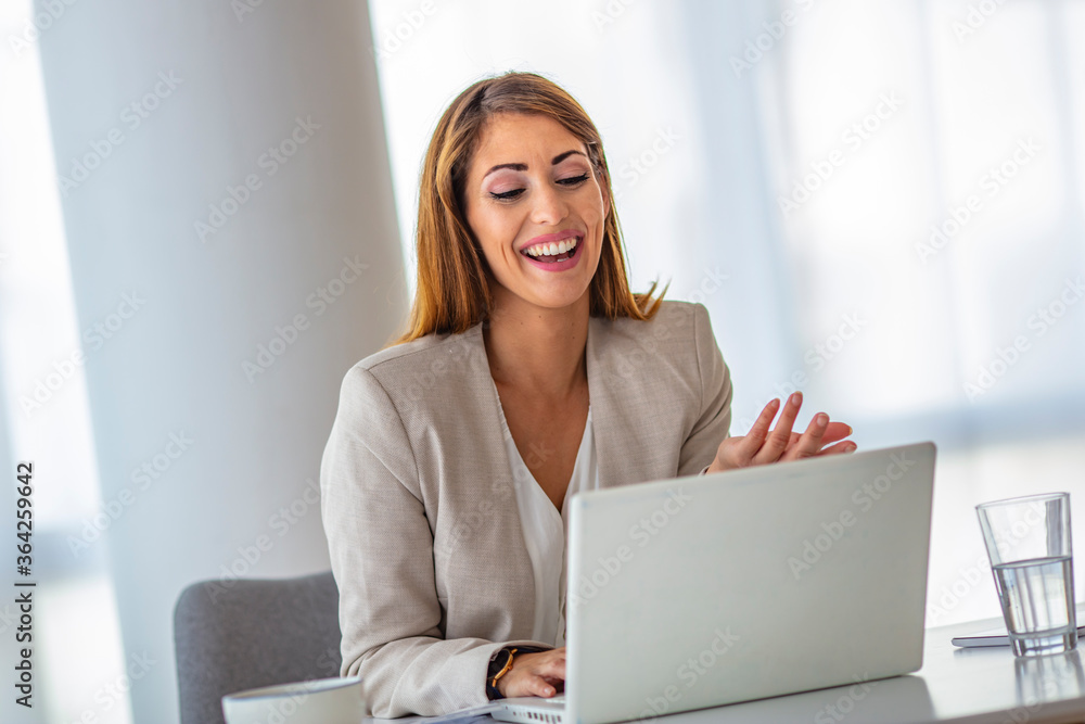 Woman in office working on laptop computer. Concentrated young beautiful businesswoman working on laptop in bright modern office. Businesswoman working at office desk and typing with a laptop Woman in office working on laptop computer. Concentrated young beautiful businesswoman working on laptop in bright modern office. Businesswoman working at office desk and typing with a laptop