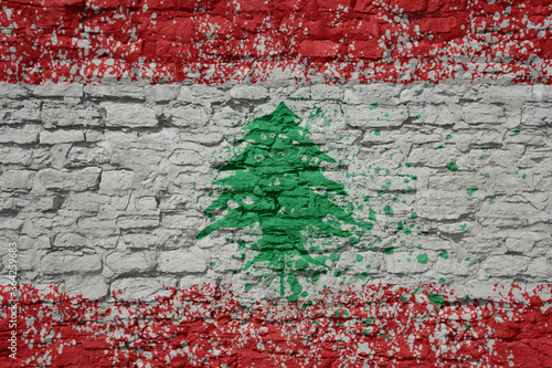 painted big national flag of lebanon on a massive old brick wall