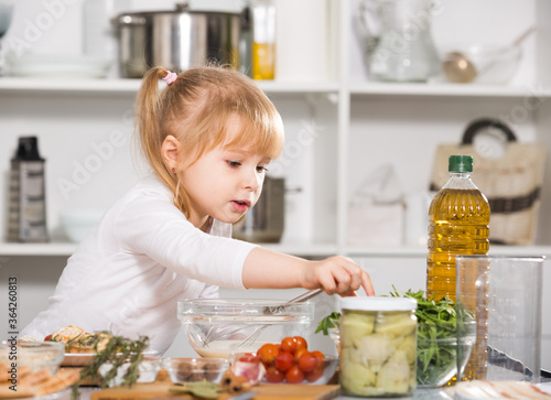 Young girl is cooking vegetables dish alone in the kitchen at home.