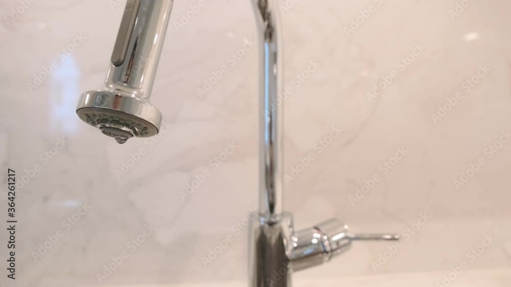 Close up of modern kitchen faucet and sink with marble surface material contertop Close up of modern kitchen faucet and sink with marble surface material contertop