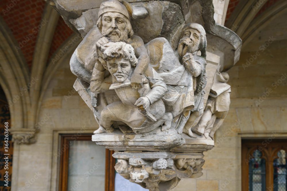 Details of the medieval architecture in Brussels. Stone building facade. Statues of men fighting on knives. Heritage and touristic concepts. Photography in summer day