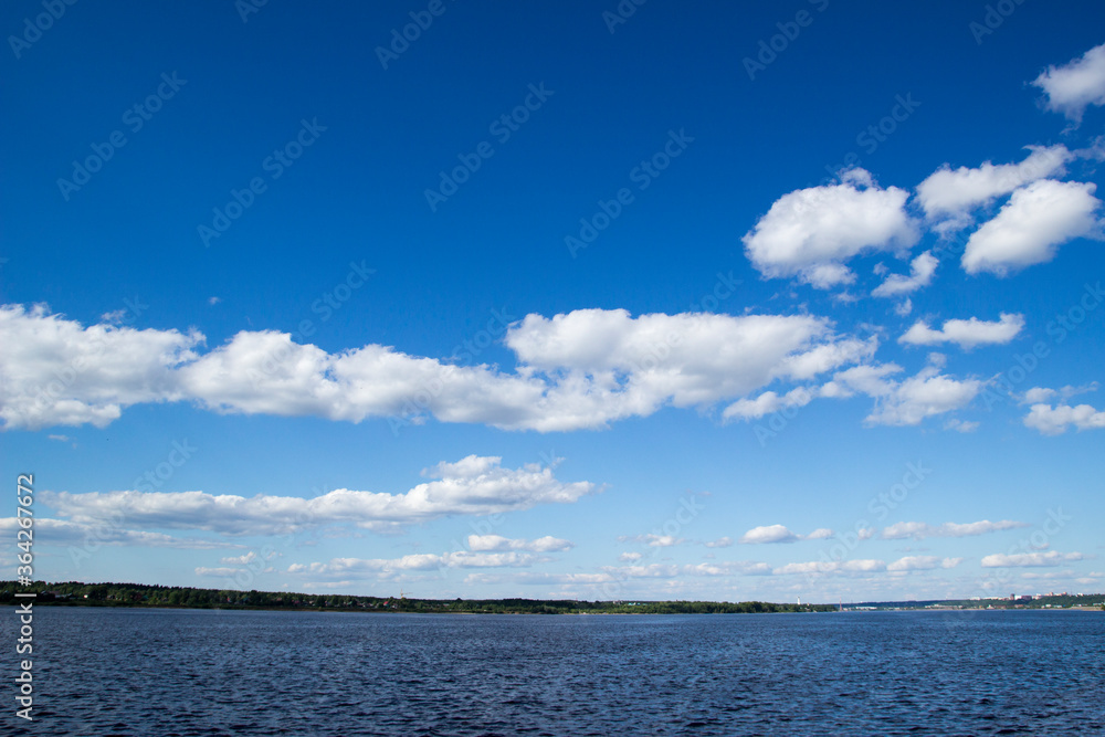 River and sky with cloud. Summer landscape with a view of the wide river. City embankment, view of the other Bank.