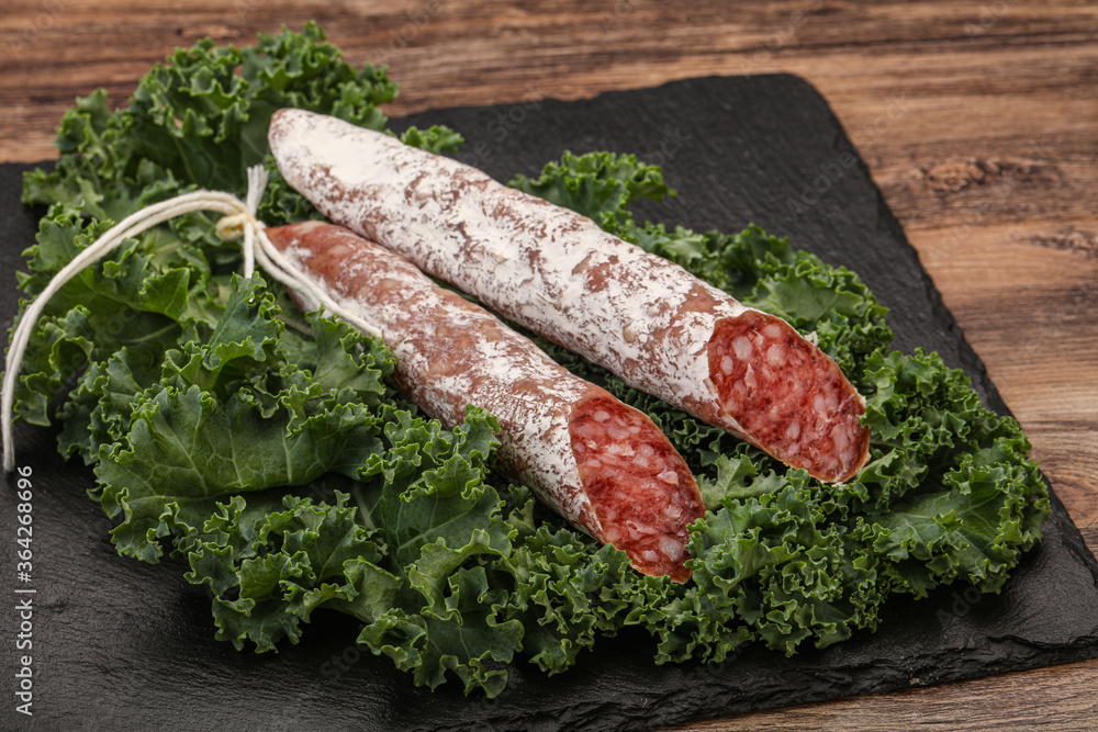 Spanish Fuet sausage with salad leaves Spanish Fuet sausage with salad leaves