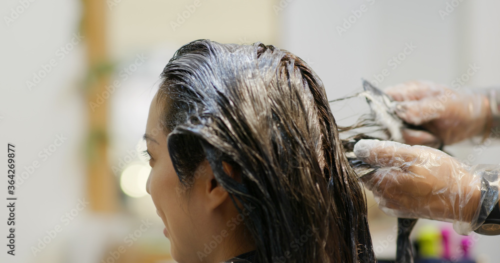 Fototapeta premium Woman dye her hair at beauty salon