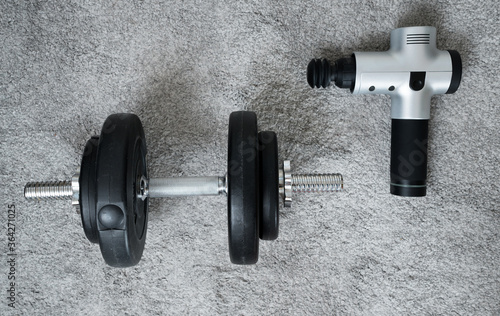 Мassage percussion gun and dumbbell. For muscle soreness and stiffness relaxation.