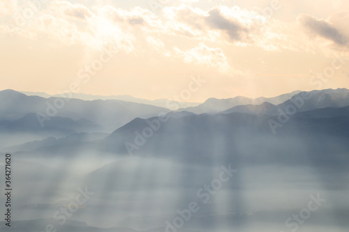 Sun shining valley light rays fog clouds sky © Patrik