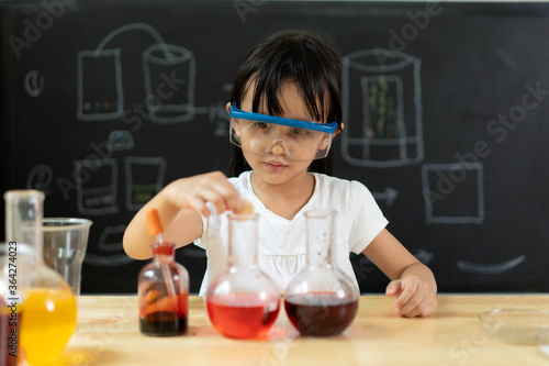 Adorable asian little girl is make easy scientific experimental at home, concept of learn from home, child STEM education and science for kid. photo