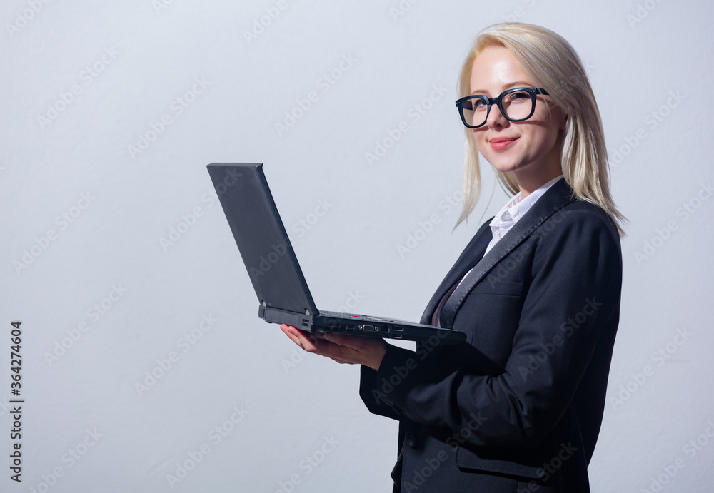 Beautiful blonde businesswoman in suit with laptop computer Beautiful blonde businesswoman in suit with laptop computer