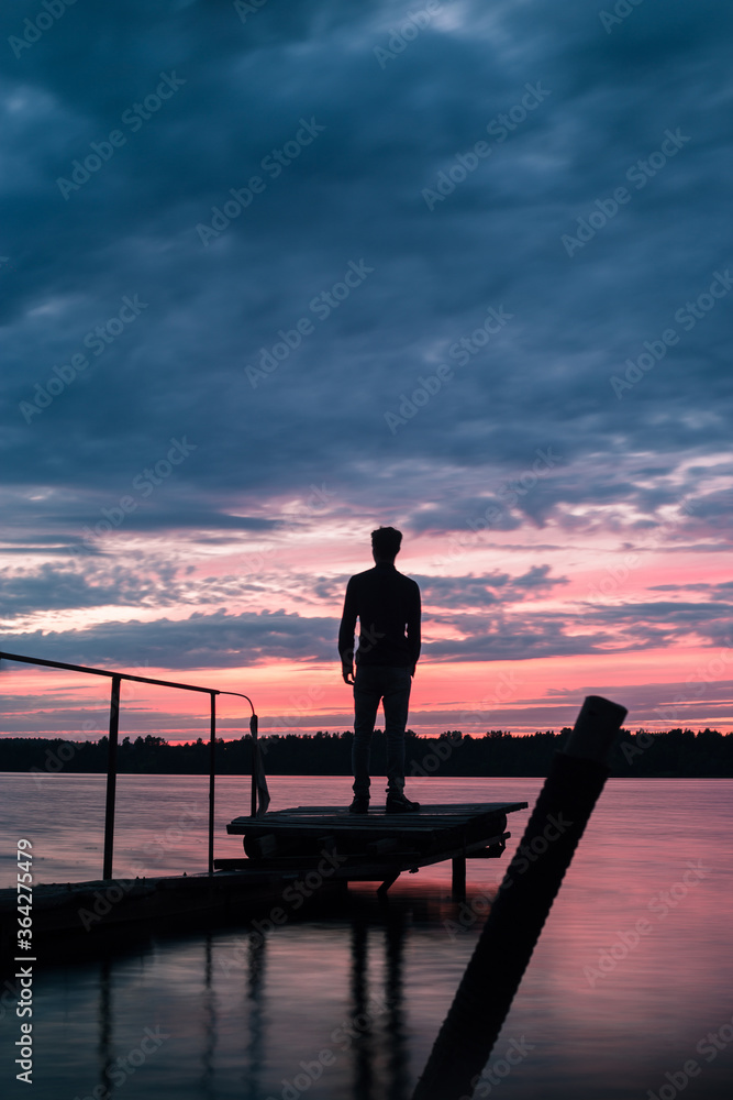 silhouette of a man standing on a pier