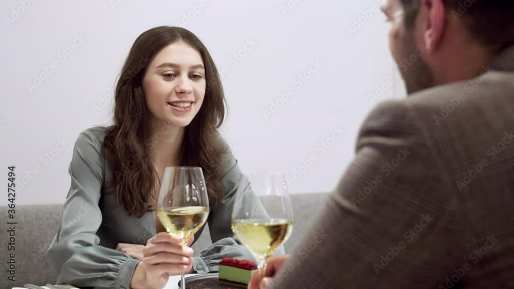 Back view of young man and woman sitting in cafe, drinking champagne and talking Back view of young man and woman sitting in cafe, drinking champagne and talking