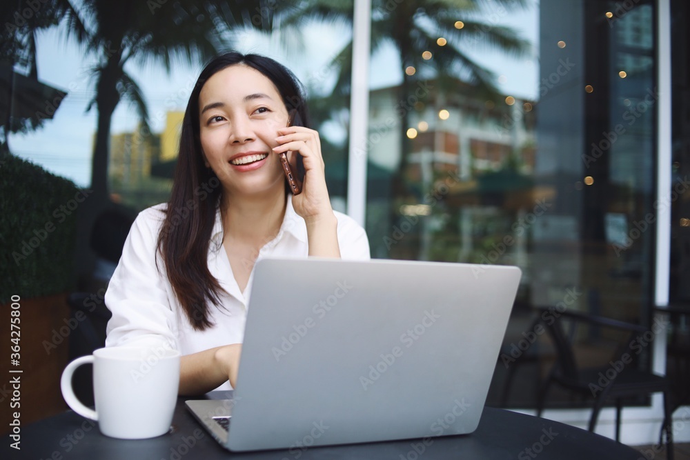 Woman talking on phone and using laptop. Woman talking on phone and using laptop.