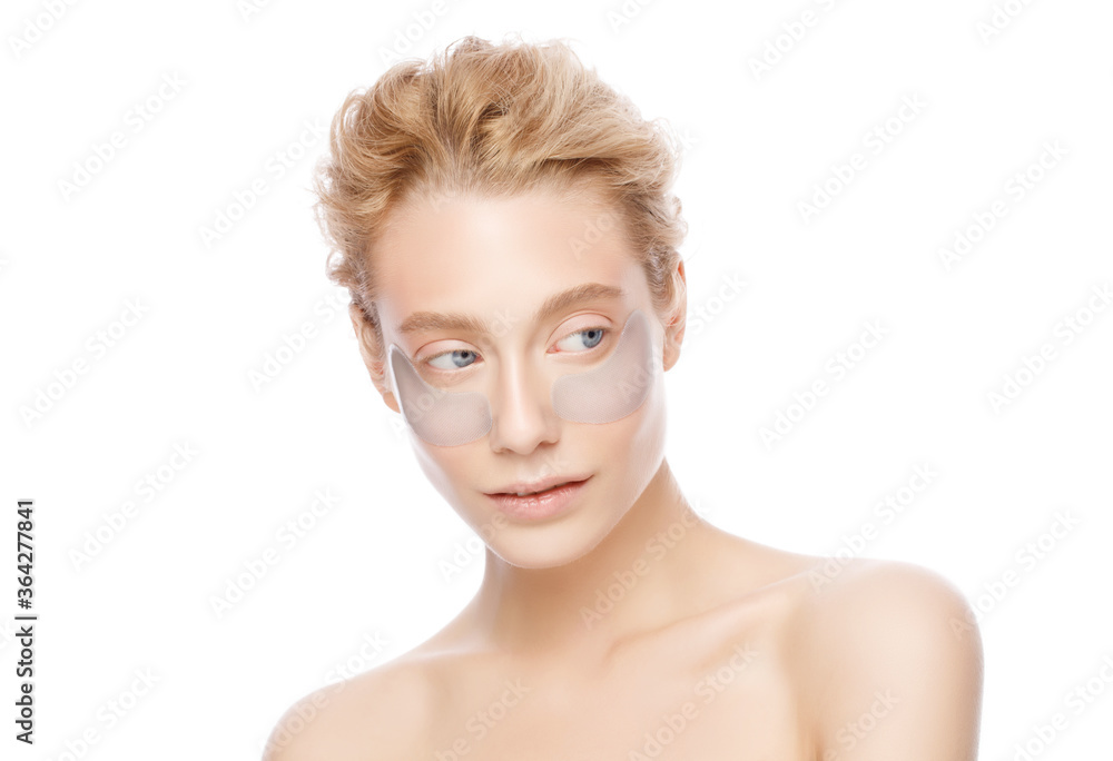 Young beautiful girl standing with naked shoulders, wearing eye patches against dark circles, isolated on white background Young beautiful girl standing with naked shoulders, wearing eye patches against dark circles, isolated on white background