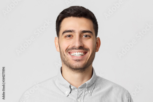 Portrait of handsome laughing business man, isolated on gray background