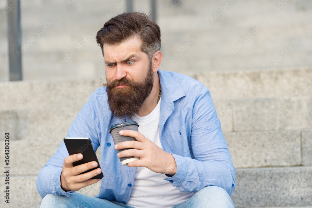 Living online life. Social networks. Modern life online communication. Guy with smartphone urban space background. Handsome bearded man relaxing mobile phone and coffee cup. Modern technology Living online life. Social networks. Modern life online communication. Guy with smartphone urban space background. Handsome bearded man relaxing mobile phone and coffee cup. Modern technology