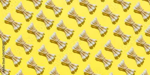 Pattern of bamboo cotton buds on a yellow background. The concept of life without waste and plastic. Zero waste