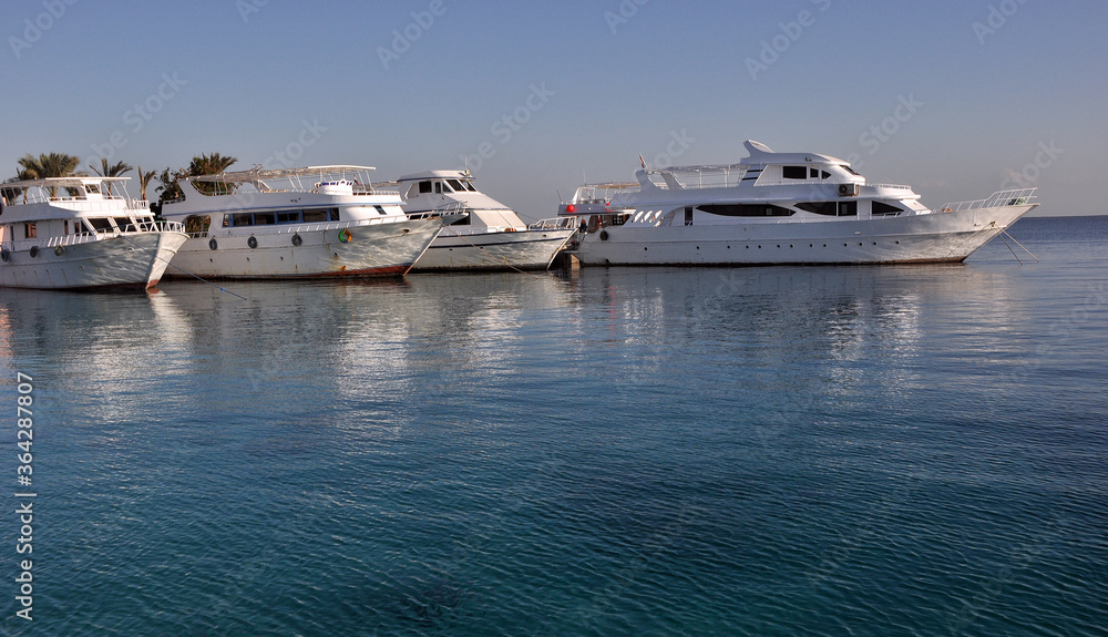 Pleasure boats in the Red Sea. Glare and reflection.