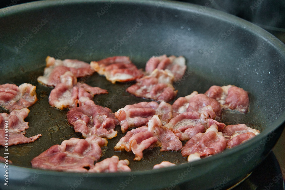 Frühstücksspeck, Schinkenspeck, Bacon beim Anbraten in einer Pfanne, American breackfast Frühstücksspeck, Schinkenspeck, Bacon beim Anbraten in einer Pfanne, American breackfast