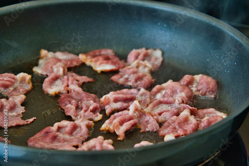 Frühstücksspeck, Schinkenspeck, Bacon beim Anbraten in einer Pfanne, American breackfast