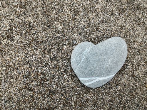 Stone heart lies in the sand. Concept of love.