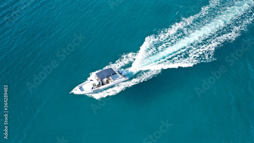Aerial drone ultra wide photo of rigid inflatable speed boat cruising in deep blue Aegean sea, Greece