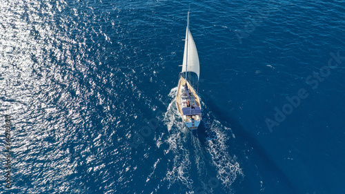 Aerial drone photo of sail boat cruising in the deep blue Aegean sea, Cyclades, Greece photo