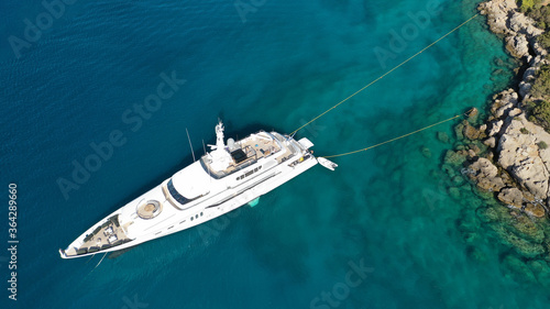 Aerial drone photo of yacht - boat with wooden deck anchored in tropical exotic paradise with turquoise open sea