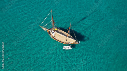 Aerial drone photo of beautiful wooden deck classic sailing yacht cruising in open ocean deep blue sea © aerial-drone