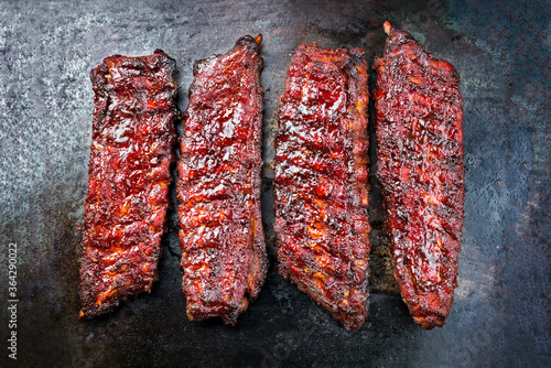 Gegrillte Spare Loin Ribs St Louis Style vom Schwein mit scharfer Honig Chili Marinade angeboten als Draufsicht auf einem alten rustikalen Bord mit Textfreiraum