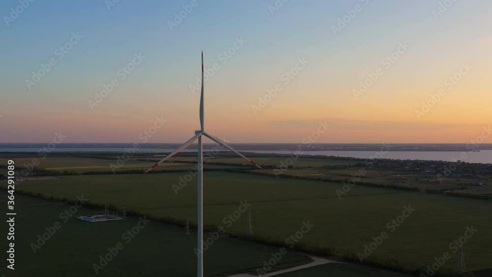Aerial 4k view of beautiful sunset meadow with wind turbine. Environment friendly energy concept Aerial 4k view of beautiful sunset meadow with wind turbine. Environment friendly energy concept