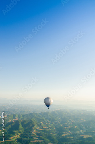hot air Balloon Flying over the mountains. Image in Vertical