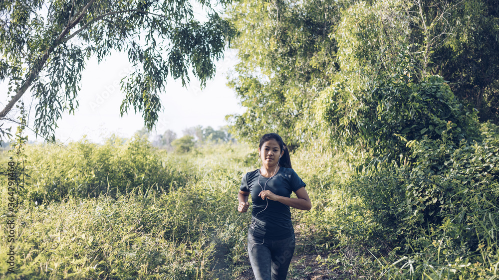 Sporty young asian woman running in park, Concepts of exercise and health maintenance