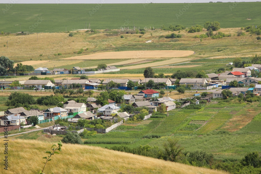 Naklejka premium Beautiful view of a Russian village from the hill. Lovely little houses.