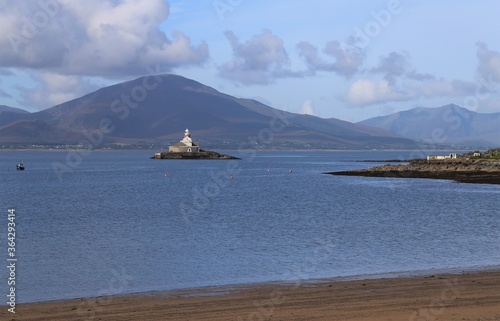 A view of Little Samphire Lighthouse with the mountains of the Dingle Peninsula, County Kerry, Ireland, in the background.