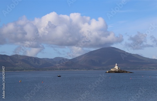 A view of Little Samphire Lighthouse in Tralee Bay  with the mountains of the Dingle Peninsula, County Kerry, Ireland, in the background. photo