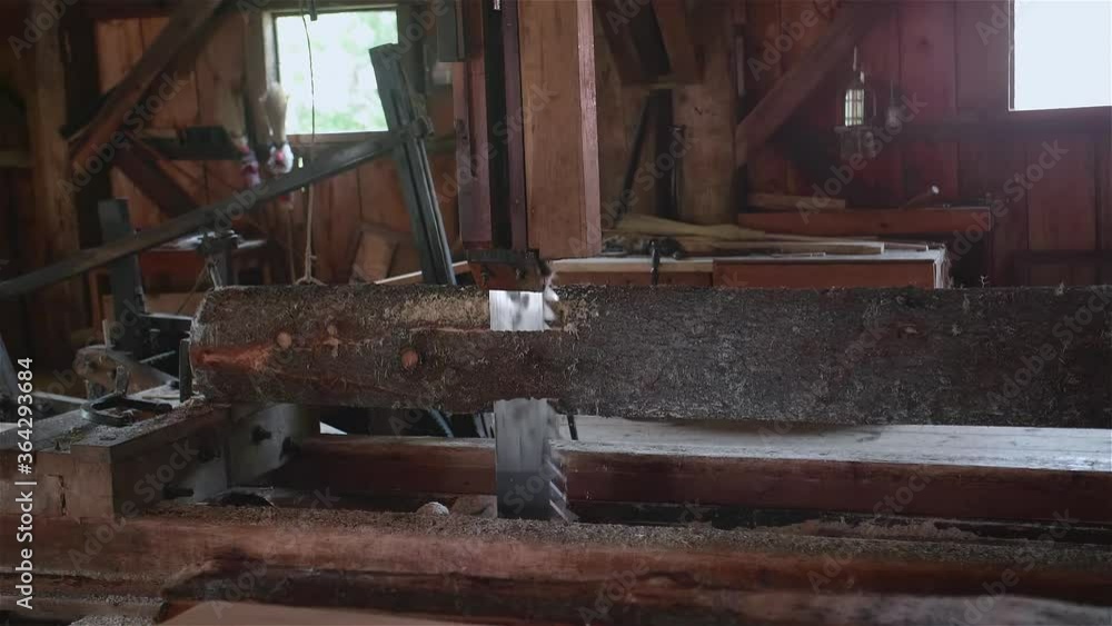 Traditional sawmill in the process of milling a log into planks using traditional methods and machinery Traditional sawmill in the process of milling a log into planks using traditional methods and machinery