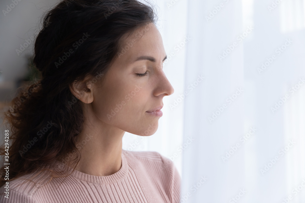Close up of calm young Caucasian woman stand with eyes closed thinking or pondering, distracted peaceful millennial female lost in thoughts, meditate or relieve negative emotions, breathe fresh air
