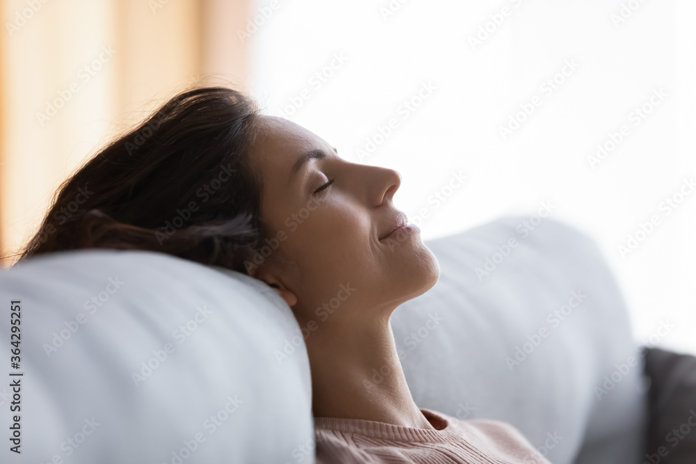 Close up of smiling calm young Caucasian woman relax on couch at home with eyes closed sleep or take nap, calm millennial female rest on sofa, daydream relieve negative emotions, stress free concept Close up of smiling calm young Caucasian woman relax on couch at home with eyes closed sleep or take nap, calm millennial female rest on sofa, daydream relieve negative emotions, stress free concept