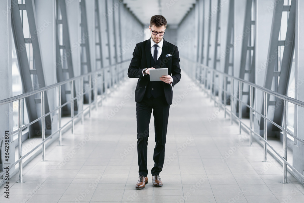 Fototapeta premium Focused urban business man holding digital tablet