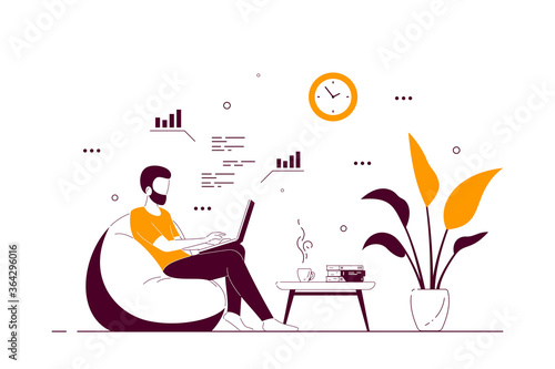Young man at home sitting in chair bag and working on computer.