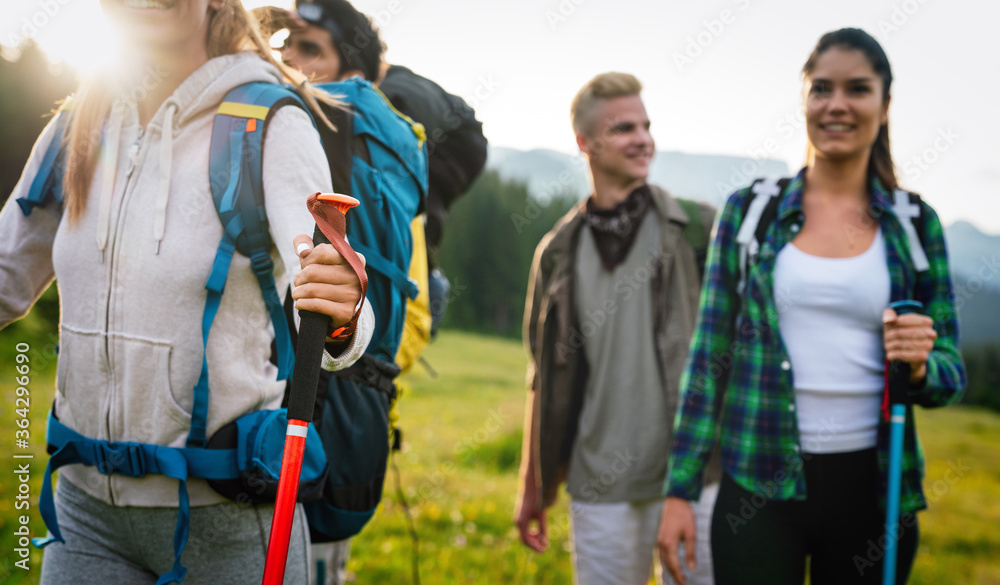 Obraz premium Trekking, hiking, camping and wild life concept. Group of friends walking together in nature