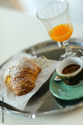 Espresso coffee, orange juice.  and custard pastry cream croissant for a caloric breakfast or coffee break, selective focus. bokeh, shallow dof photo