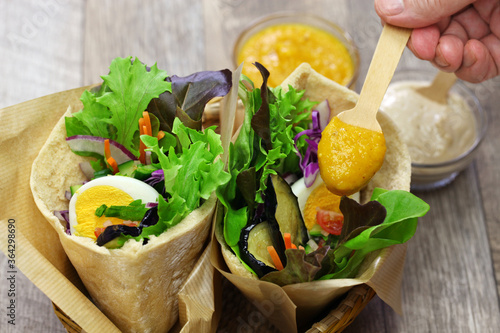 sabich: israeli pita sandwich with fried eggplant, hard boiled egg, israeli salad, amba and tahini souce photo