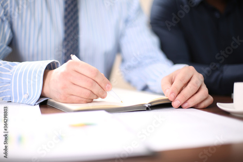 Closeup of a business man writing in Notepad classic business