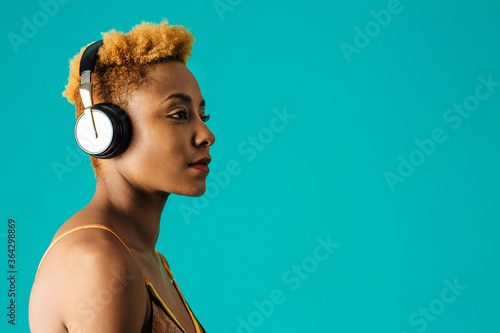 Profile portrait of a cool young woman with headphones listening to music