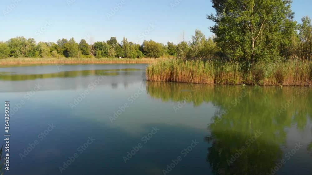 Drone shot of a man fishing on a lake during summer Drone shot of a man fishing on a lake during summer