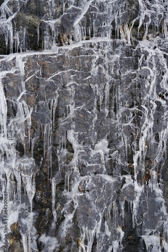 Icy waterfall background against a rocky wall Icy waterfall background against a rocky wall